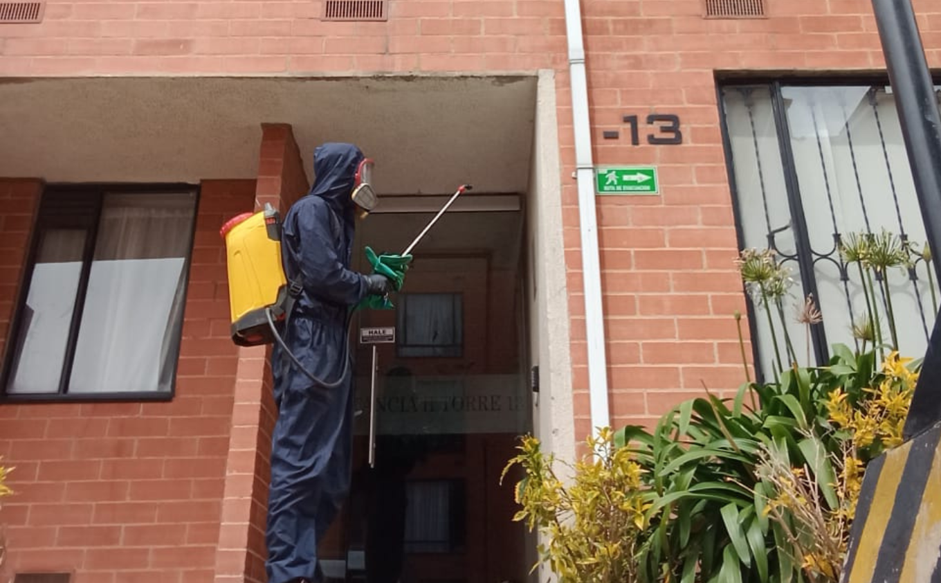 Técnico realizando labores de control de plagas en un edificio residencial
